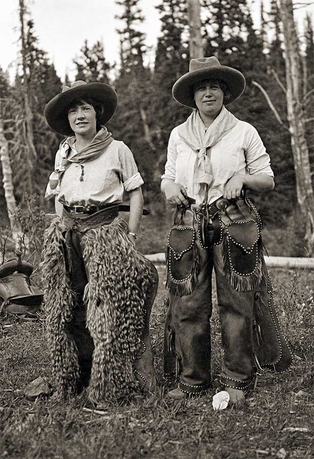 two cowgirls wearing chaps